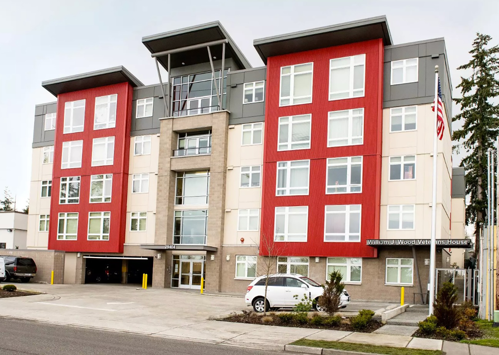 Modern apartment building with red and beige facade.
