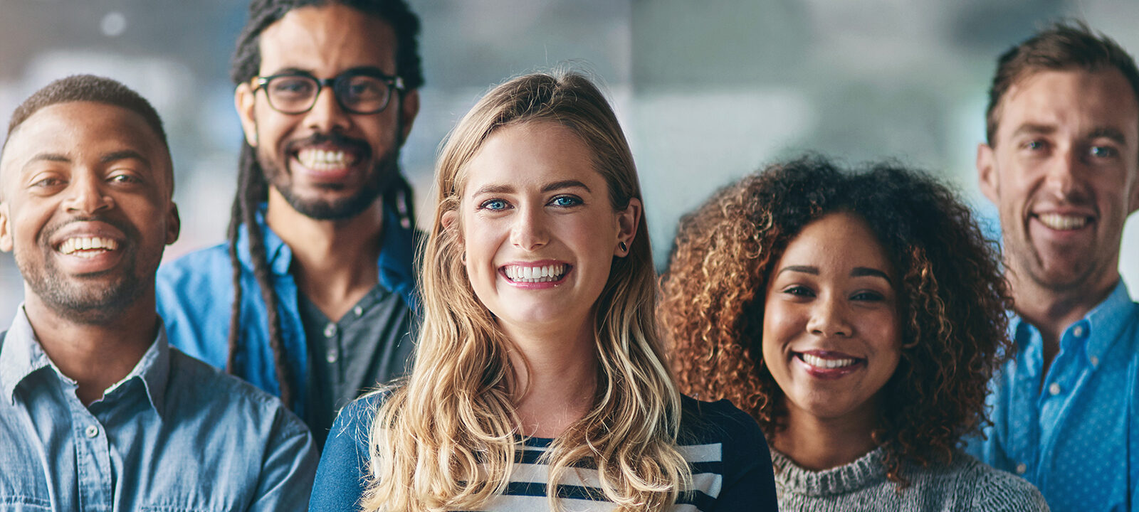 Group of smiling people of diverse backgrounds and hairstyles.
