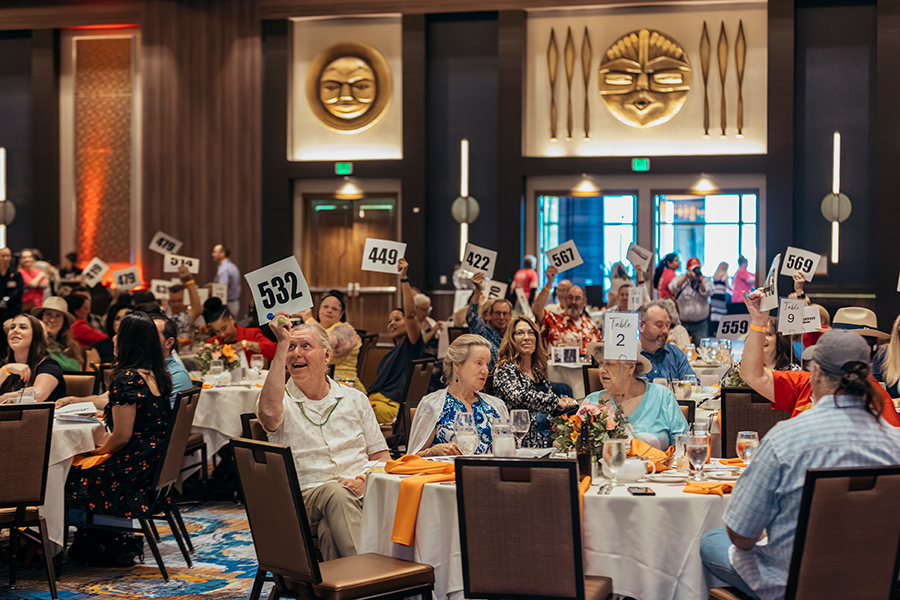 People at tables holding numbered signs, likely participating in an event.
