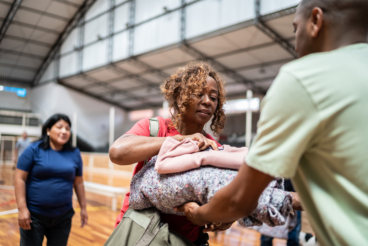 Woman handing blankets to worker