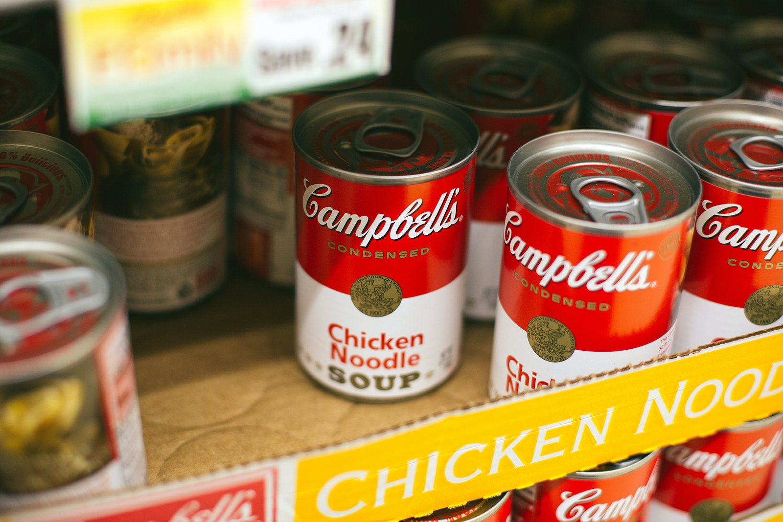 Cans of Campbell's Chicken Noodle Soup on a shelf.