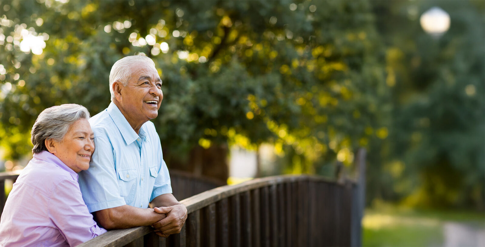 Elderly couple enjoying a moment together outdoors, smiling.