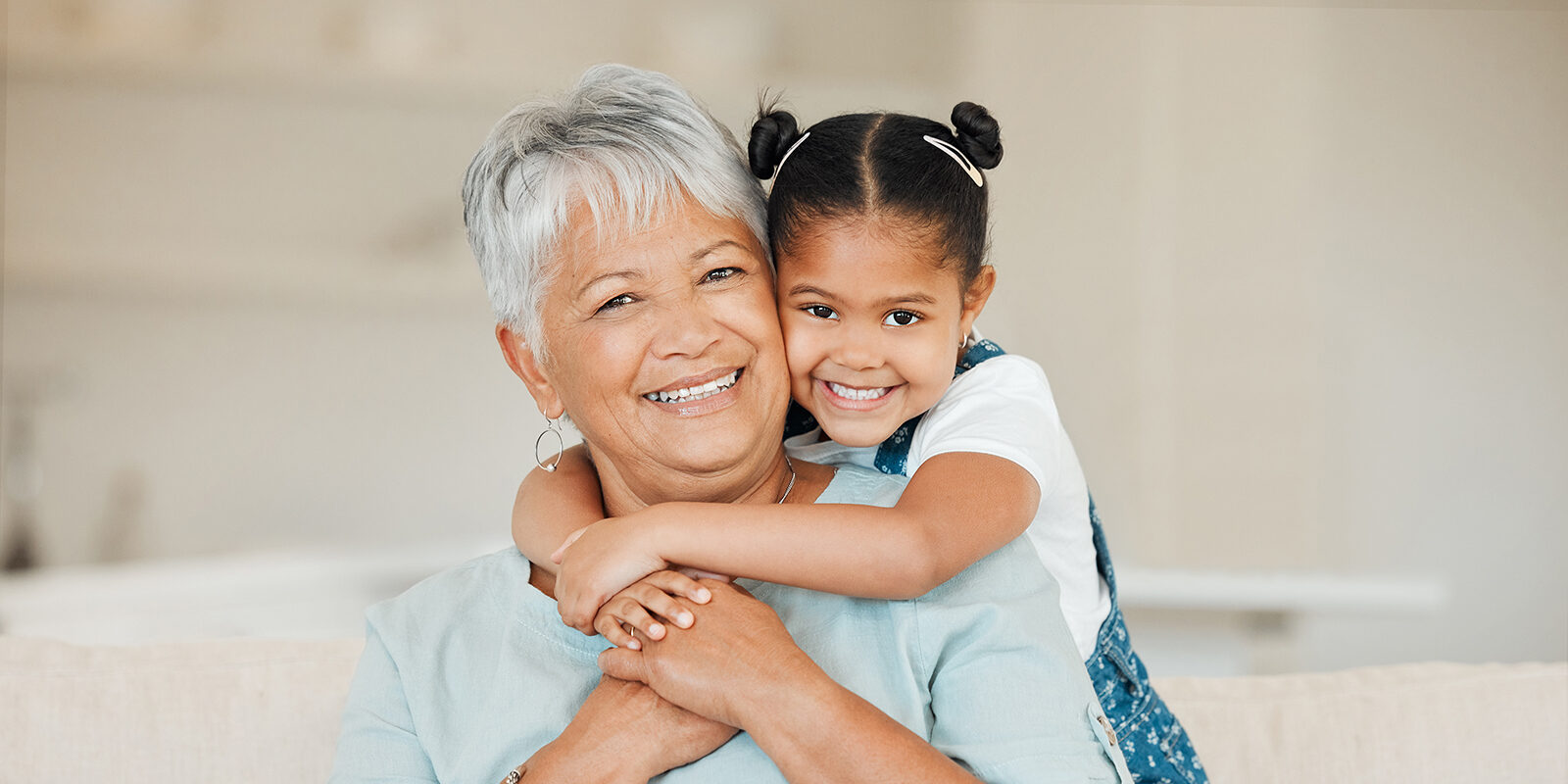 Happy grandmother and granddaughter embracing and smiling together.