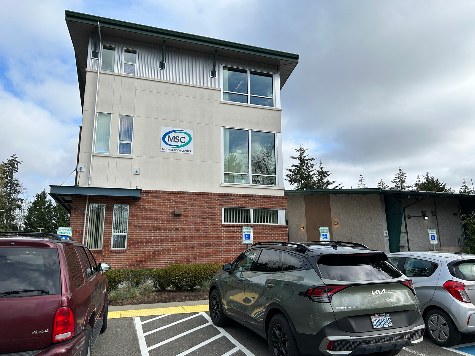 Multi-Service Center building with parked cars outside.