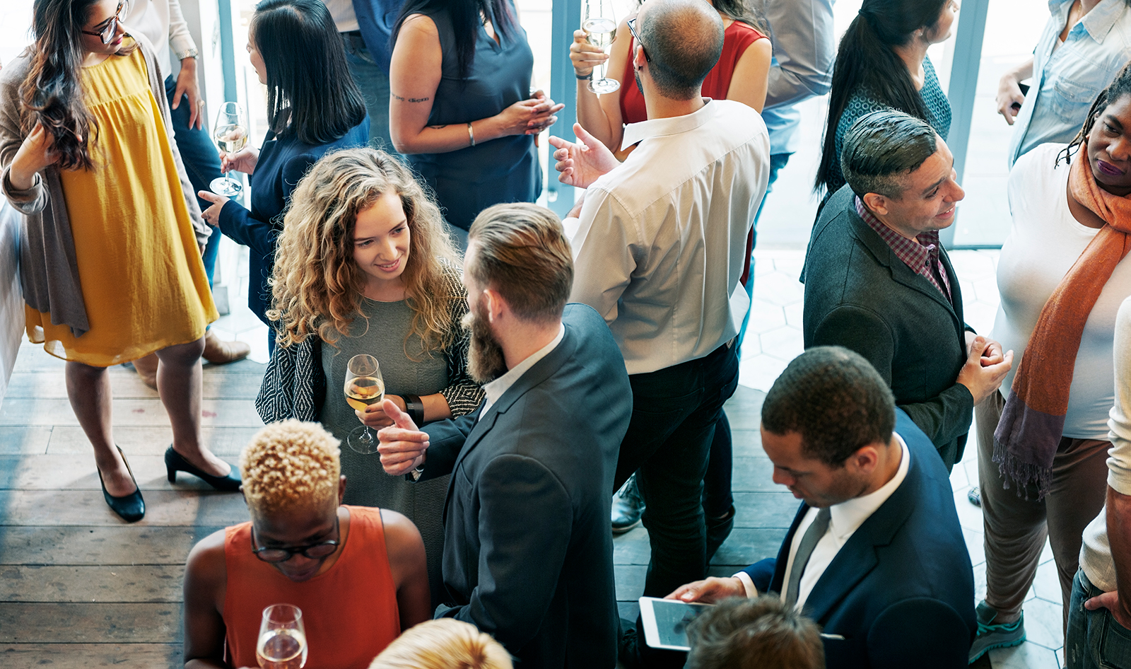 People socializing, enjoying drinks at a lively gathering.