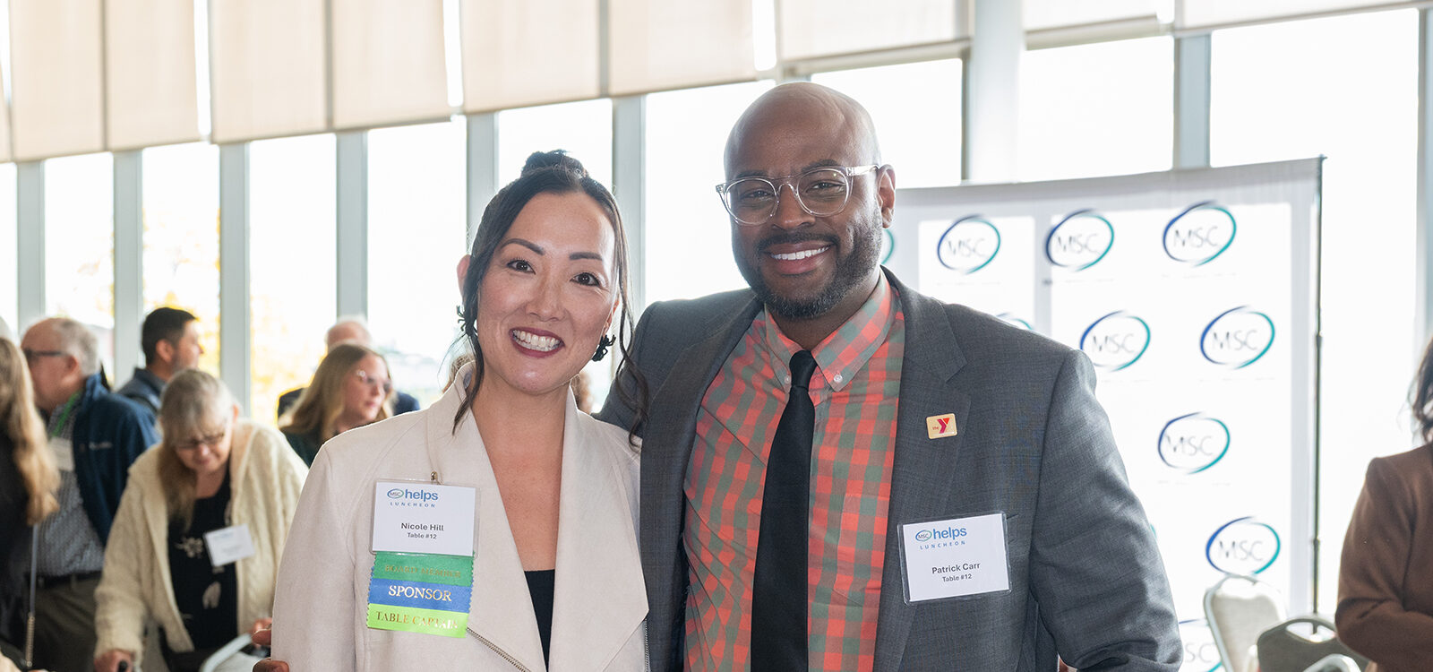 Two smiling individuals at a networking event.