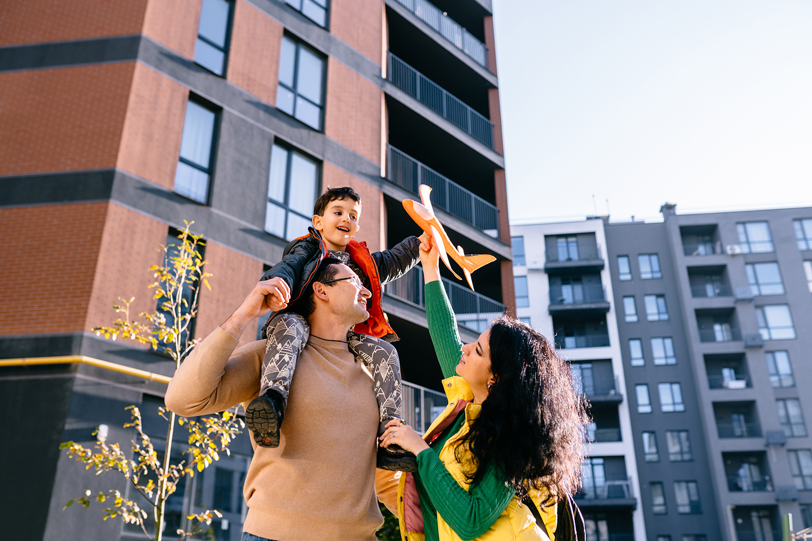 Family enjoying time outdoors, child playing with airplane.