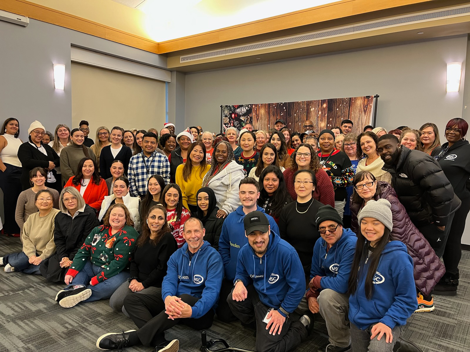 Large group photo, people smiling, festive attire, cheerful atmosphere.
